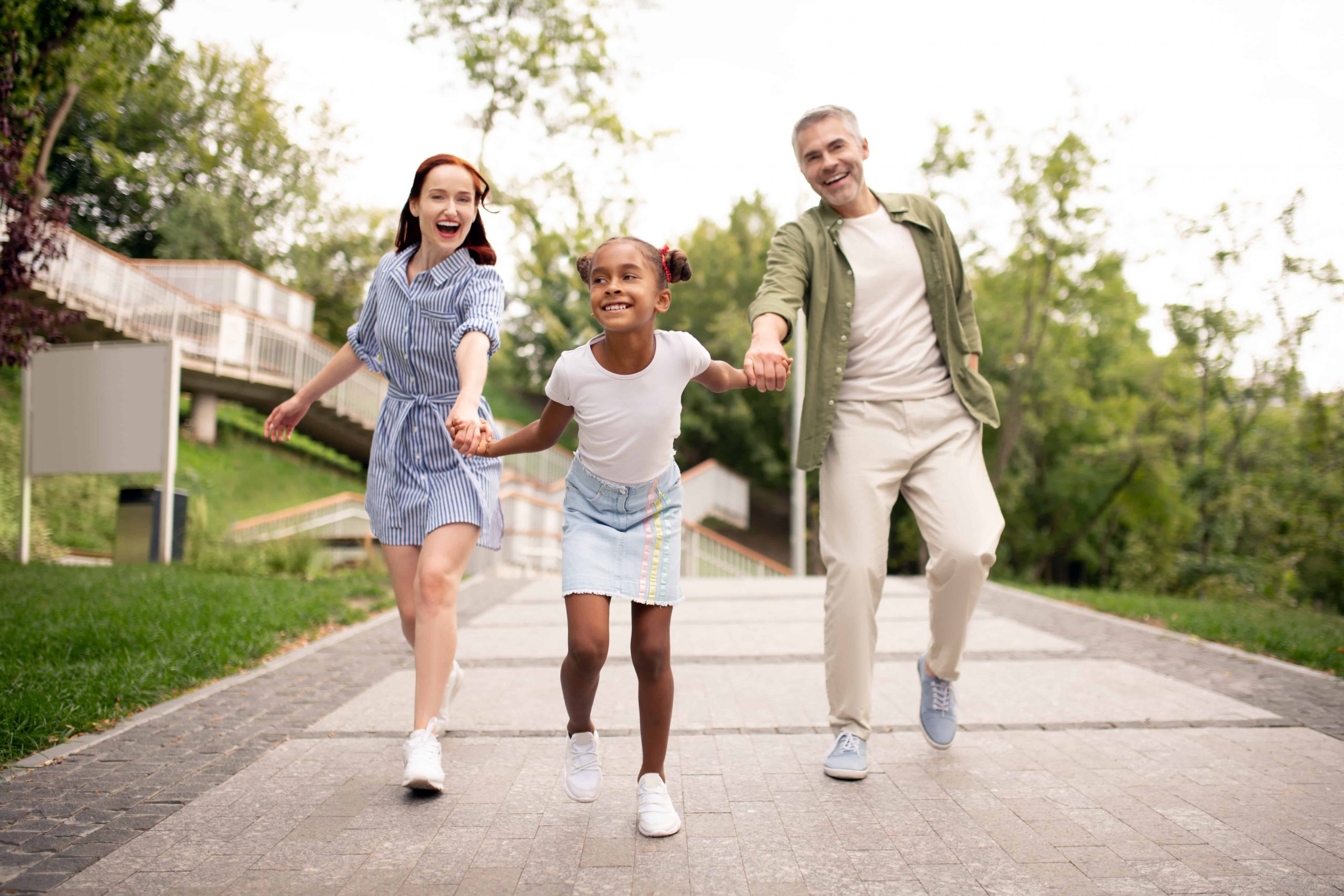 Energetic and happy foster family taking a walk together outside