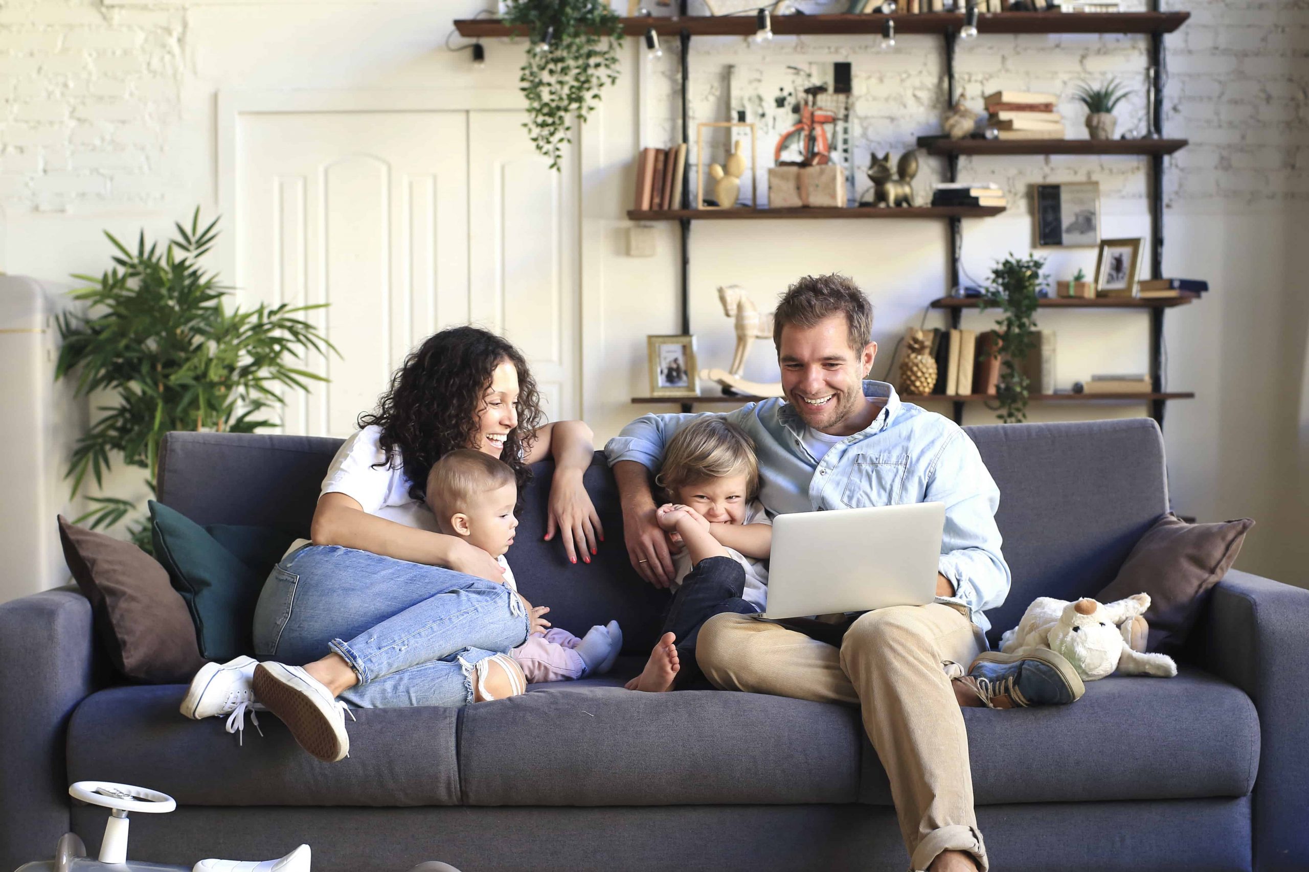 Happy Young adoptive Family enjoying each other on couch