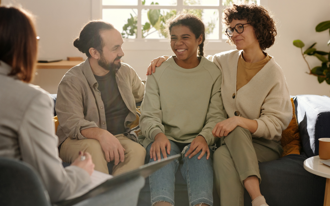 Social worker interviewing two parents and child during home study.