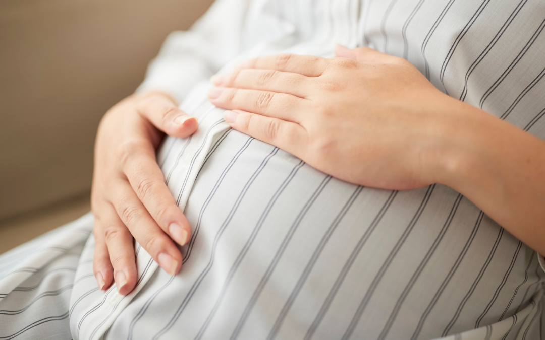 Birth mother holding stomach while considering her adoption plan.